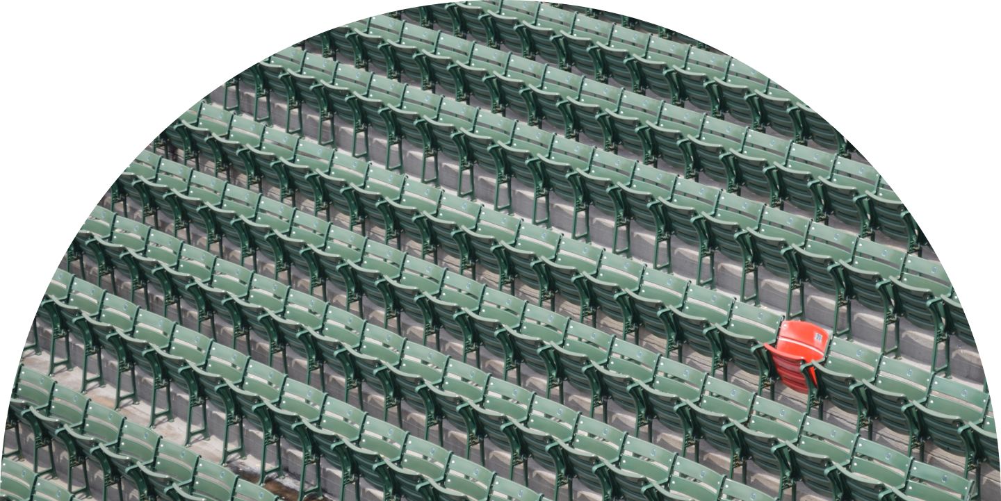 Rows of green stadium seats with one orange seat